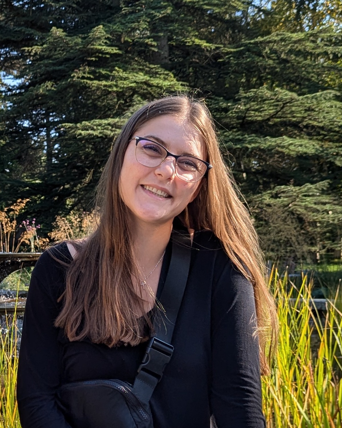 Headshot of Paige Keus smiling in a garden setting.